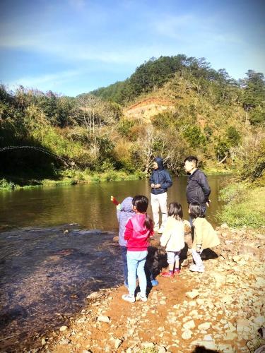 a group of people standing on the shore of a river at Tuyên Chiến Home - Nhà Gỗ in Ấp An Kroët