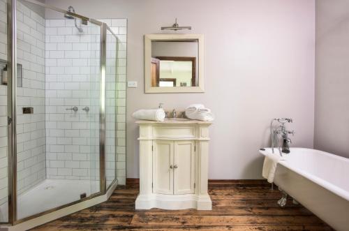 a bathroom with a tub and a sink and a shower at Winter Rose - gorgeous gardens sleeps 5 in Olinda
