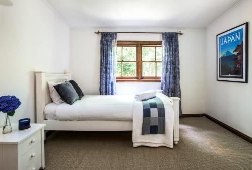 a bedroom with a bed and a window at Winter Rose - gorgeous gardens sleeps 5 in Olinda
