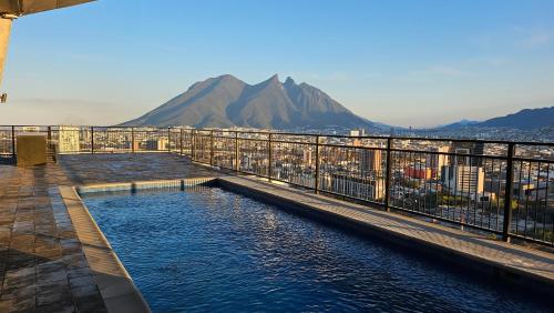 a swimming pool on top of a building with a mountain at Depto Centro de Monterrey by tuhost in Monterrey