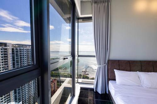 a hotel room with a bed and a large window at Urban Suites with Spectacular High Floor View #3BR #03 in Jelutong