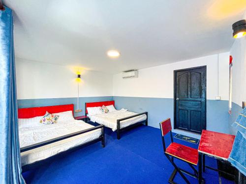 a room with two beds and a chair in it at CORAL in Koh Rong Sanloem