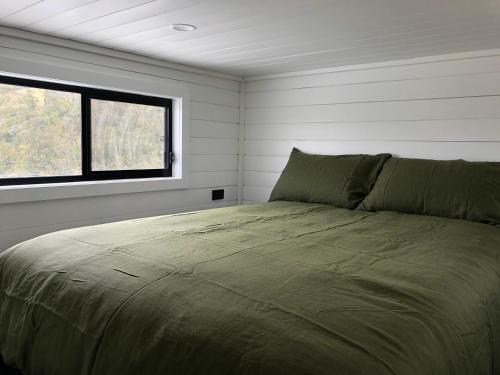 a bed in a room with a window at Tiny Zoe in Mount George