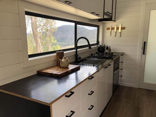 a kitchen with a counter with a sink and a window at Tiny Zoe in Mount George