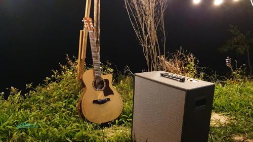 a guitar and a speaker next to a guitar amp at Tuyên Chiến Home - Nhà Gỗ in Ấp An Kroët