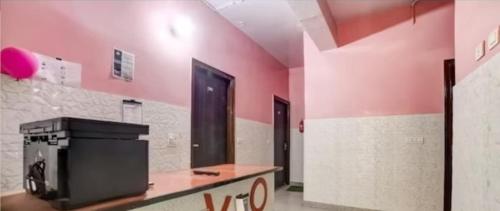 Cette chambre est dotée de murs roses et d'un comptoir avec une télévision. dans l'établissement Tarun guest house, à Palwal
