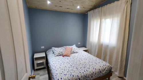a bedroom with a bed and a blue wall at Casa Charlotte in San José