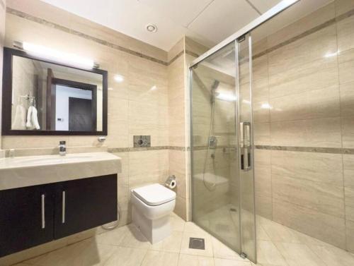 ein Bad mit einem WC, einer Dusche und einem Waschbecken in der Unterkunft Luxurious three-bedroom Villa. in Ras al Khaimah