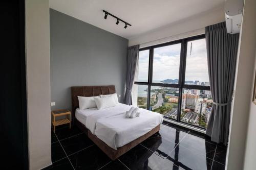 a bedroom with a bed and a large window at Urban Suites with Spectacular High Floor View #3BR #10 in Jelutong