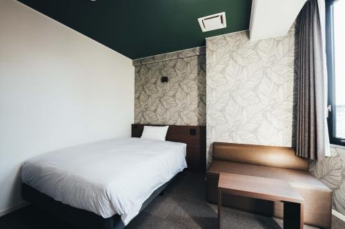 Dormitorio pequeño con cama y mesa en TAPSTAY HOTEL - Vacation STAY 35036v, en Saga