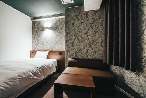 Habitación pequeña con cama y banco en TAPSTAY HOTEL - Vacation STAY 35036v, en Saga