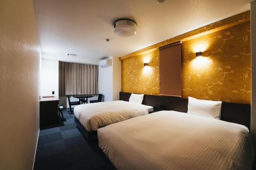 佐賀市にあるTAPSTAY HOTEL - Vacation STAY 35228vのベッド2台とテーブルが備わるホテルルームです。