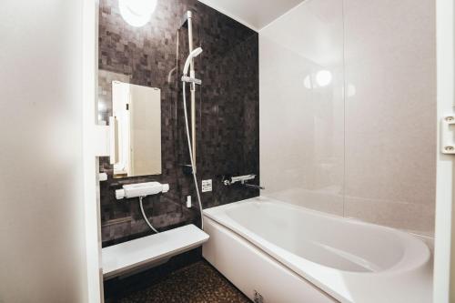 ein Badezimmer mit einer Badewanne und einem Waschbecken in der Unterkunft TAPSTAY HOTEL - Vacation STAY 35228v in Saga