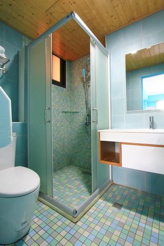 a bathroom with a shower and a toilet and a sink at 优閒民宿 in Kenting