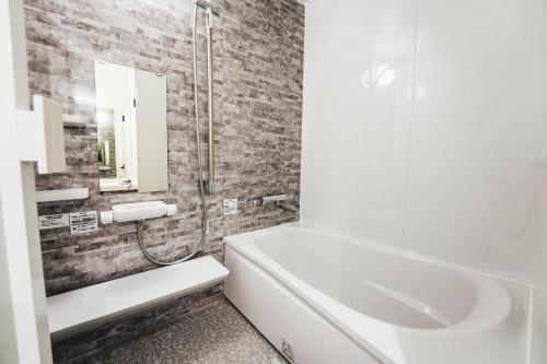 a bathroom with a white tub and a sink at TAPSTAY HOTEL - Vacation STAY 35227v in Saga