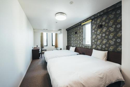 - une chambre avec 2 lits et un mur dans l'établissement TAPSTAY HOTEL - Vacation STAY 35232v, à Saga