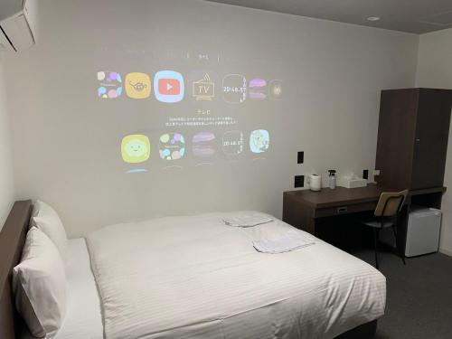 um quarto com uma cama e uma secretária com uma parede em TAPSTAY HOTEL - Vacation STAY 35238v em Saga