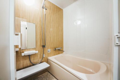 La salle de bains est pourvue d'une baignoire et d'un lavabo. dans l'établissement TAPSTAY HOTEL - Vacation STAY 35232v, à Saga