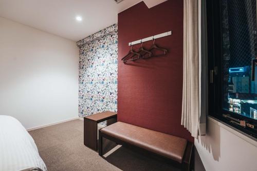 Dormitorio con banco junto a la pared en TAPSTAY HOTEL - Vacation STAY 35235v, en Saga