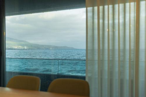 a view of the ocean from a window at SeaLux Apartment (Seaside) in São Roque