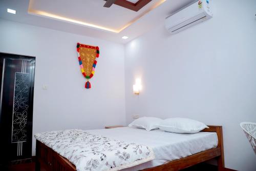 1 dormitorio con 1 cama con sábanas blancas en Isha Marari Beach homestay, en Mararikulam