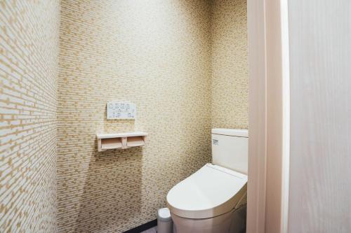 a small bathroom with a toilet and a tiled wall at TAPSTAY HOTEL - Vacation STAY 35203v in Saga
