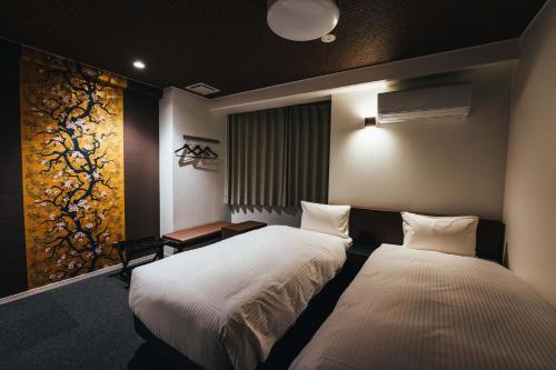 佐賀市にあるTAPSTAY HOTEL - Vacation STAY 35230vのベッドルーム1室(ベッド2台付)が備わります。壁には絵画が飾られています。