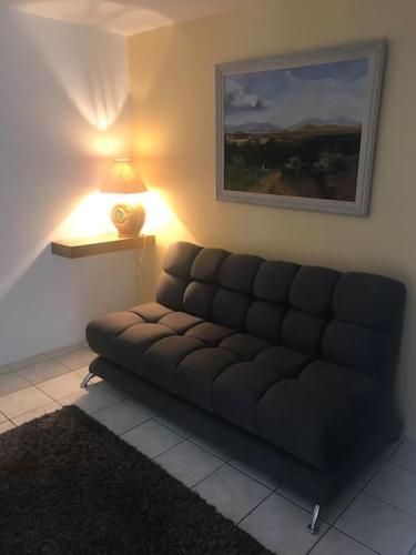 een bank in een woonkamer met een lamp bij Habitacion #1 in Chihuahua
