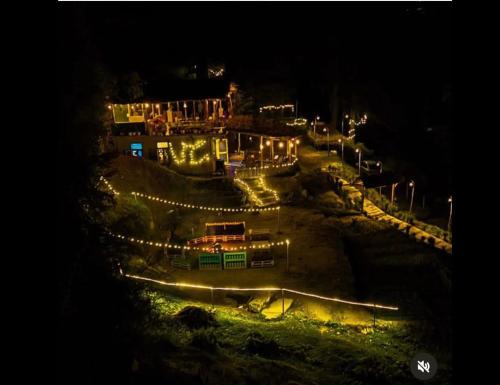 uma vista nocturna para um parque de skate com luzes em Unwind Stays em Nagar