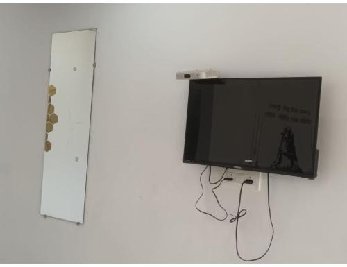 a flat screen tv hanging on a wall at Hotel PJ Dupeex, Ravigram, Phata in Phata