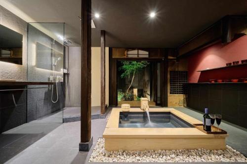 a bathroom with a bath tub with a shower at Kyoto Machiya Zeniyacho in Kyoto