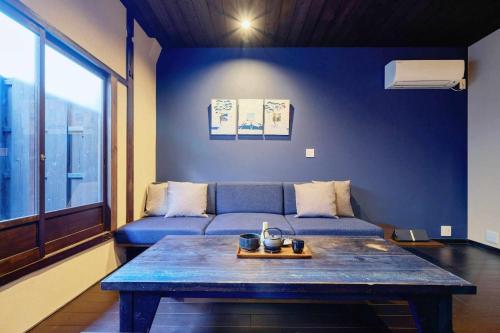 a living room with a blue couch and a table at Kyoto Machiya Zeniyacho in Kyoto