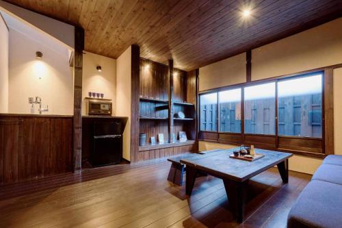 a living room with a table and a large window at Kyoto Machiya Zeniyacho in Kyoto