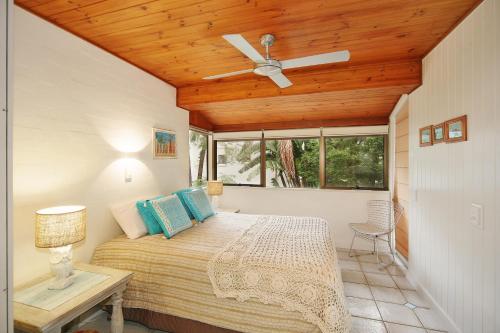 1 dormitorio con 1 cama y ventilador de techo en Tea Trees Apartment 4, Little Cove, en Noosa Heads