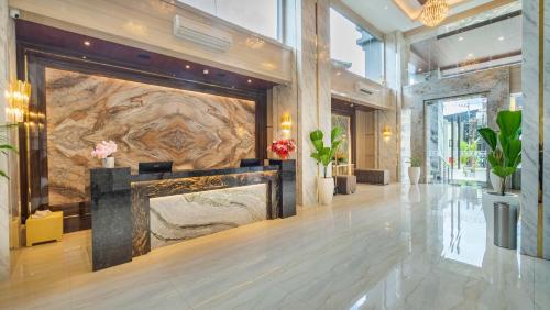 a lobby with a large stone wall with a fireplace at City of Aventus Hotel - Denpasar in Denpasar