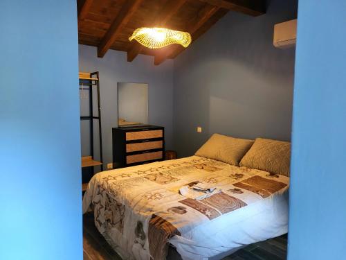 a bedroom with a bed and a chandelier at L anghjuledda 2 in Grosseto-Prugna