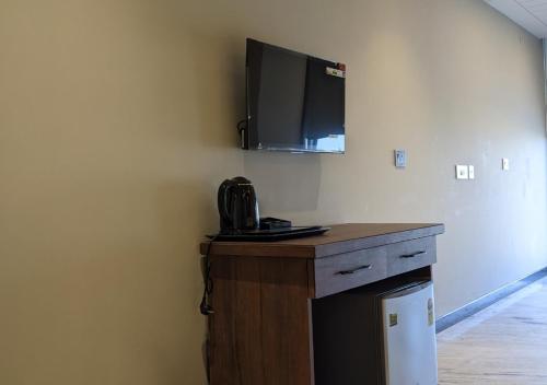 a room with a desk with a tv on the wall at All Starr Club in Jaipur