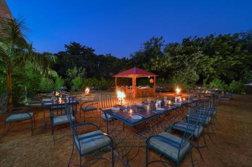 a long table with chairs and a gazebo at night at Jungle Vilas in Sawāi Mādhopur