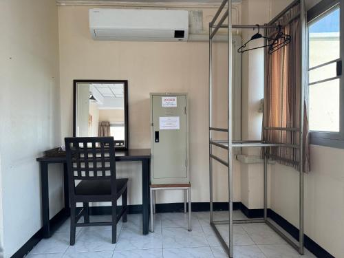 a chair in a room with a desk and a mirror at KC guest house in Bangkok