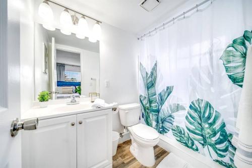 a white bathroom with a toilet and a shower curtain at Adorable Condo in Peaceful Area - Palm Wave Says in Coconut Creek
