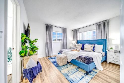 - une chambre avec un lit bleu et une tête de lit bleue dans l'établissement Adorable Condo in Peaceful Area - Palm Wave Says, à Coconut Creek