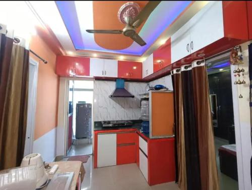 une cuisine avec des placards rouges et blancs et un ventilateur de plafond dans l'établissement Aparna sarin park, à Kondapur