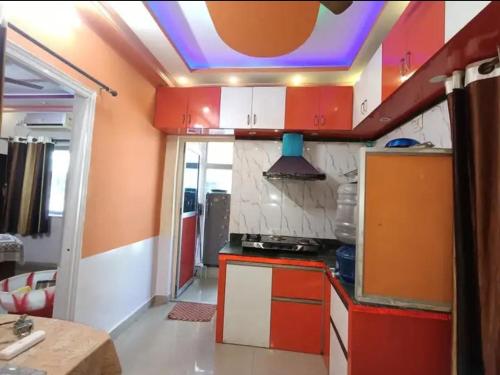 une cuisine avec des placards rouges et blancs et un plafond pourpre dans l'établissement Aparna sarin park, à Kondapur