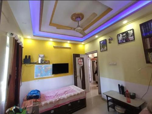 Cette chambre au plafond comprend un lit et une table. dans l'établissement Aparna sarin park, à Kondapur