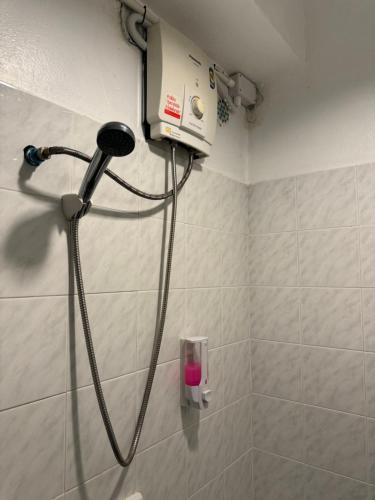 a shower in a bathroom with a blow dryer at KC guest house in Bangkok