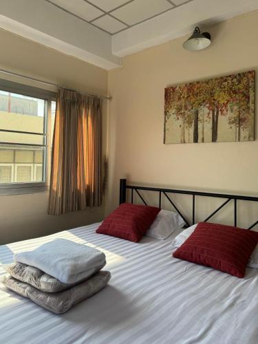 a bedroom with two beds with red pillows on them at KC guest house in Bangkok