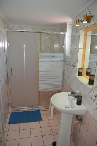 a bathroom with a sink and a shower with a mirror at Melia Studios in Kato Daratso