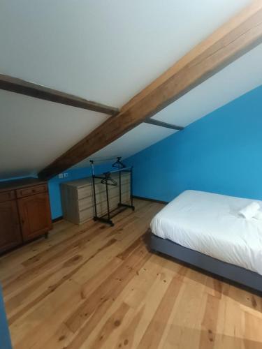 - une chambre avec un lit et un mur bleu dans l'établissement Le gîte du Vivier - Loches, à Loches