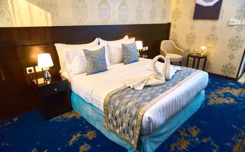 a hotel room with a bed with swans on it at Selat Al Bait Hotel in Makkah