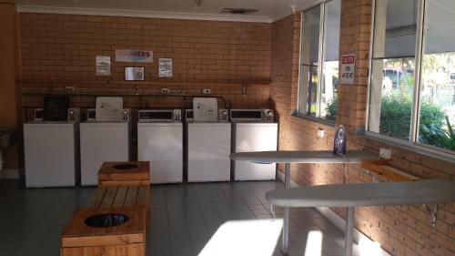 a room with a row of washers and dryers at Smugglers Cove Holiday Village in Forster